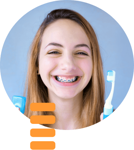 Webb Orthodontics - young girl smiling while wearing her braces and holding a toothbrush and floss