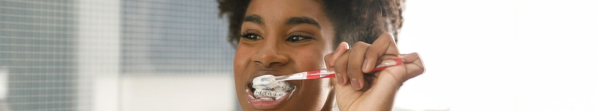 Webb Orthodontics - young girl brushing her braces