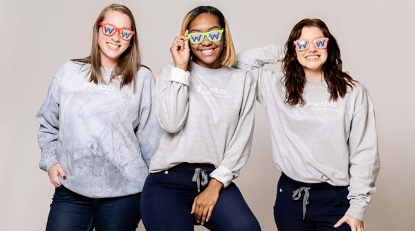 three girls smiling with glasses