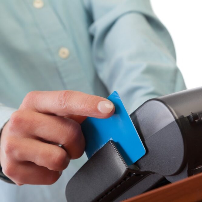 Human hand with credit card swipe through terminal for sale. invisalign asheville